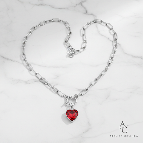 Red Heart Zircon Toggle Necklace flat lay op marmer met Atelier Celinéa logo