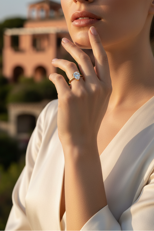 Vrouw draagt Gold Pear Solitaire Ring in zonnige setting
